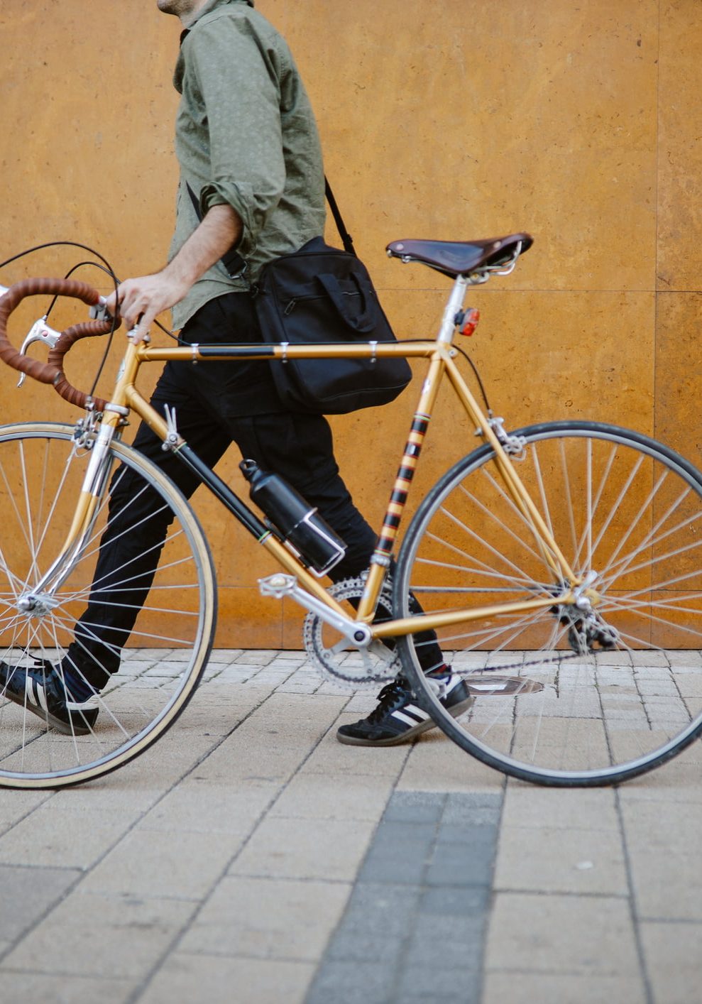 Commuter pushing his vintage road bicycle on the pavement, getting to work.